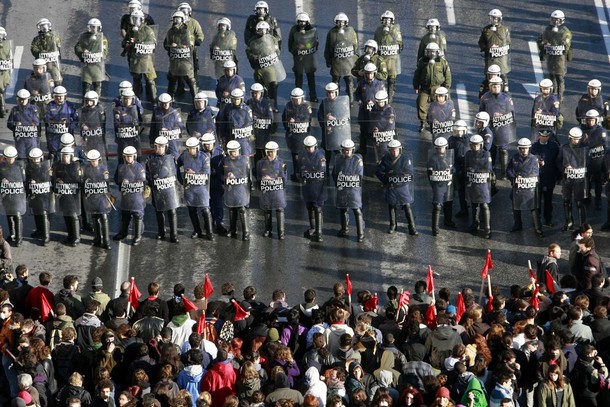 Protesters march towards formation of police officers outside parliament in central Athens